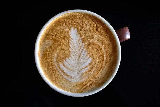 Top-Down View of Hot Latte with Rosetta Latte Art on Black Background.
