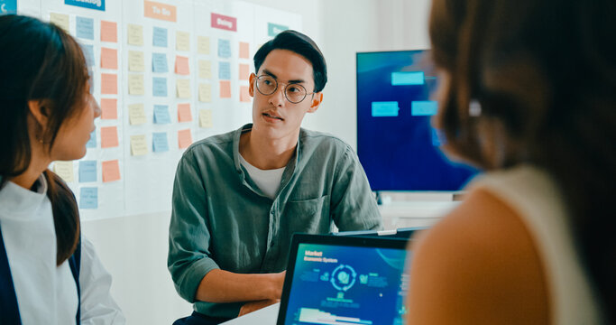 Group of Asian businesspeople work together discuss plan idea with investment data profit sale statistics in business meeting in office. Financial generation z team brainstorm on e-Commerce project.