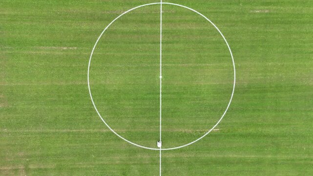 Aerial top-down view of autonomous robot painting white lines on a football/soccer field
