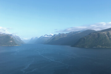 Storfjorden fjord with steep mountain slopes in the Sunnmore region of Norway. Beautiful arctic coastline and distant peaks stretching along a calm fjord from Leirvagfjellet viewpoint near Alesund. © vaitekune
