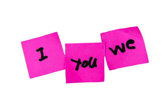 Three pink sticky notes with handwritten words I, you, and we isolated on a white background