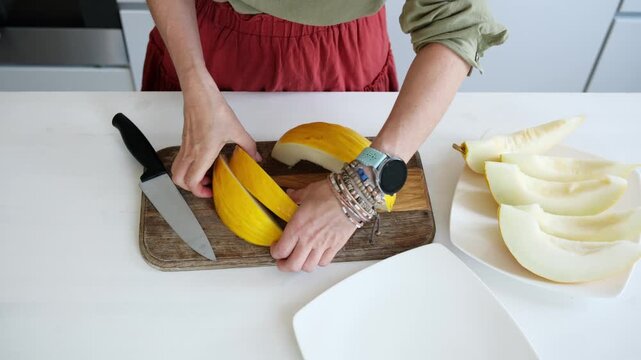 Woman Slicing Melon Into Pieces Viewed From Above Close-Up View