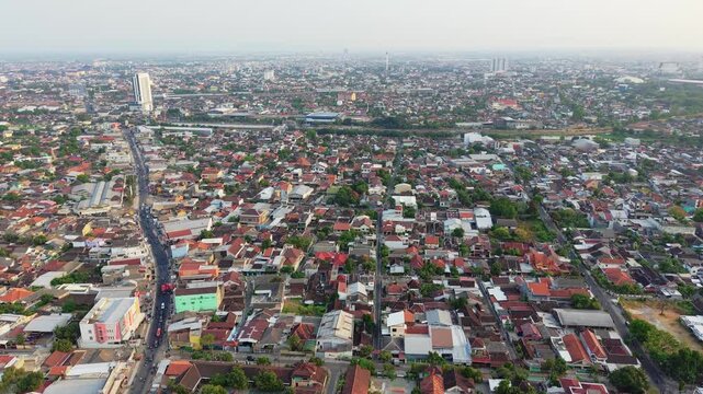 Aerial view of the dense urban landscape of Surakarta with residential rooftops and busy streets in Surakarta, Central Java, Indonesia.