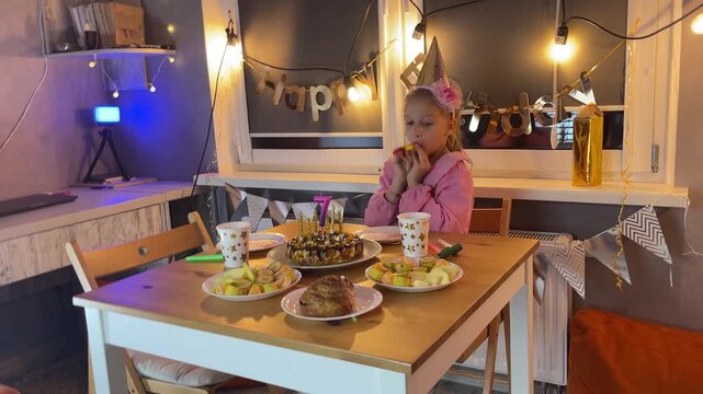 Father and daughter home celebrating birthday together with cake and fairy lights