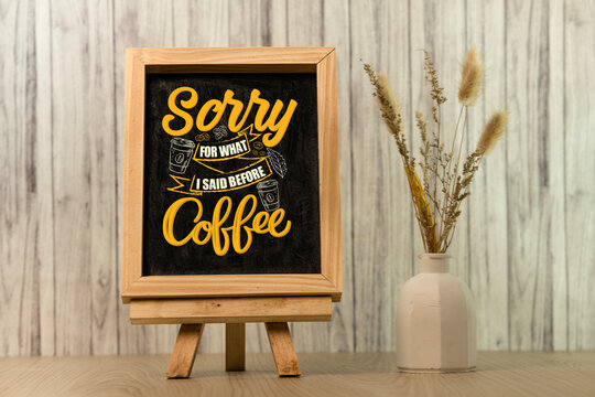 Chalkboard sign with coffee quote on wooden easel with dried flowers and rustic background