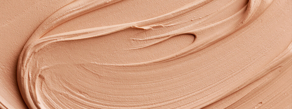 Swirled liquid foundation texture. Smooth nude beige cosmetic makeup cream stroke