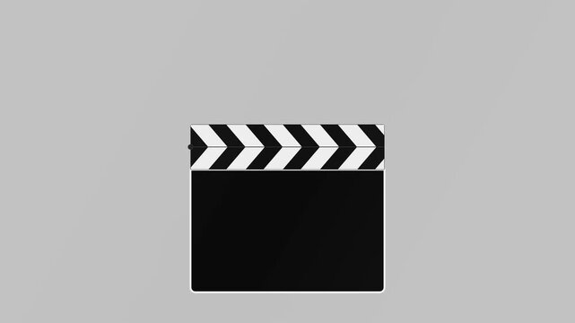 Movie clapperboard sits closed against a minimalist light grey background in a simple studio setup.