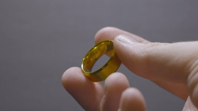 Rotating a gold wedding band around the finger.