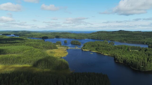 Drone flying backwards over a Lakeland landscape, summer at Savij&auml;rvi , Koli