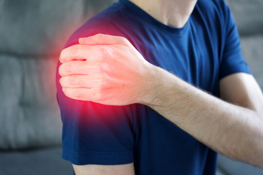 Man holding side of arm below shoulder suffering from subacromial bursitis pain