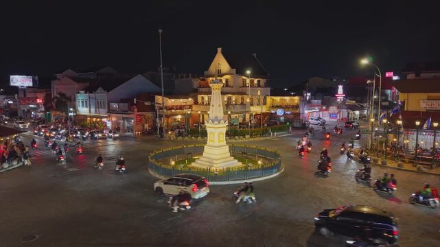 Aerial view of Tugu Yogyakarta Monument at night with traffic circulating around the illuminated landmark in Yogyakarta, Special Region of Yogyakarta, Indonesia.