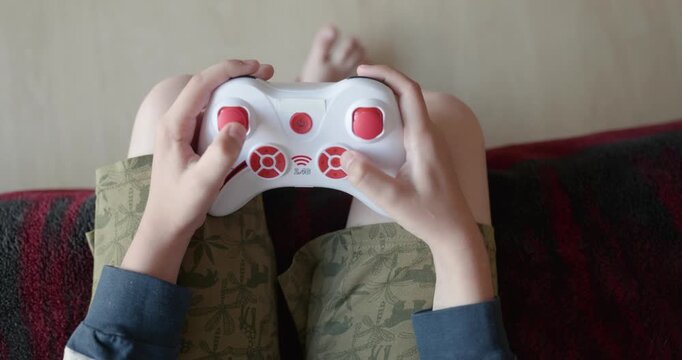 Close-up children's hands use joystick game controller playing video games. 4K 10-bit