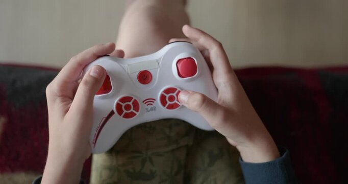 Close-up children's hands use joystick game controller playing video games. 4K 10-bit