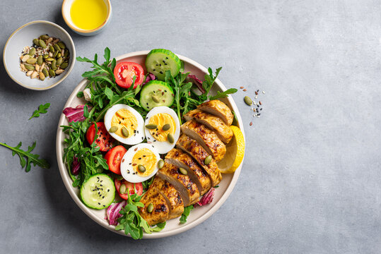 High protein lunch bowl with chicken, eggs and vegetable salad