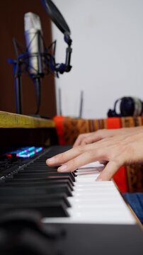 Music producer composing song on midi keyboard