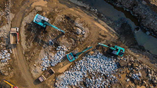 Aerial View of Heavy Earthmoving Machinery Group of Excavators Working in a Large-Scale Rock Ore Quarry. Mining Site Work from Above.