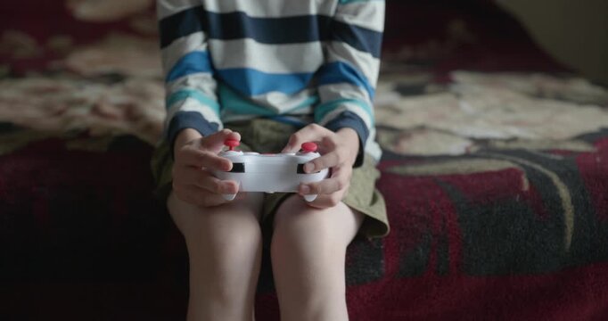 Close-up children's hands use joystick game controller playing video games. 4K 10-bit