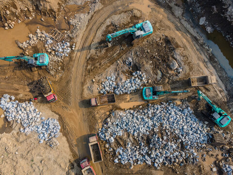 Aerial View of Heavy Machinery work in a Large-Scale Rock Ore Quarry During Morning Viewed from Above in Dawuhan Kulon, Central Java, Indonesia.