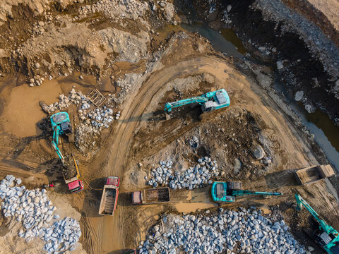 Aerial View of Heavy Machinery work in a Large-Scale Rock Ore Quarry During Morning Viewed from Above in Dawuhan Kulon, Central Java, Indonesia.