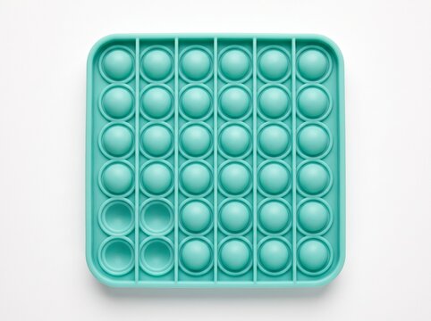 Mint green silicone push bubble fidget toy top view on white background, square sensory toy with pressed and raised domes