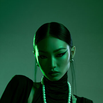 neon green portrait of an elegant east asian woman with pearls, dramatic beauty portrait with bold eyeliner and neon lighting, futuristic portrait of an woman with slicked back hair