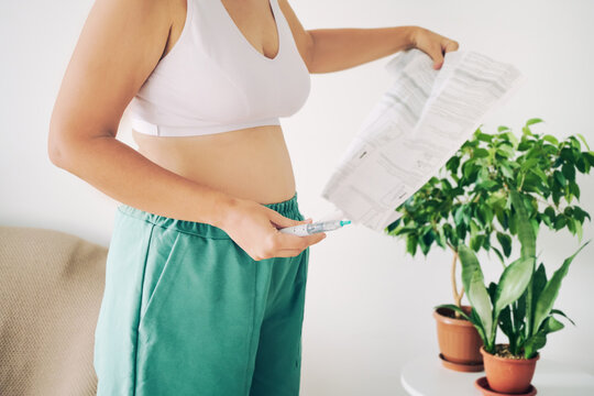 Woman reading instructions while preparing an GLP-1 injection for health and weight loss