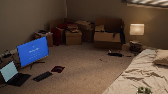 Computer monitor displaying network connection screen on floor beside laptop and moving boxes during zoom out. Visual asset ideal for internet service provider ads and student housing promotions