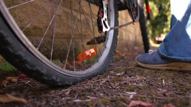 Cyclist wheeling bicycle with flat tyre