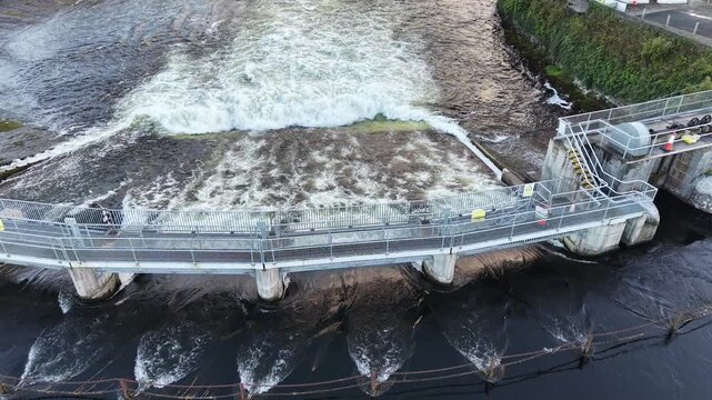 Aerial view of turbulent water flowing through Salmon Weir infrastructure on the River Corrib in Galway City Ireland.