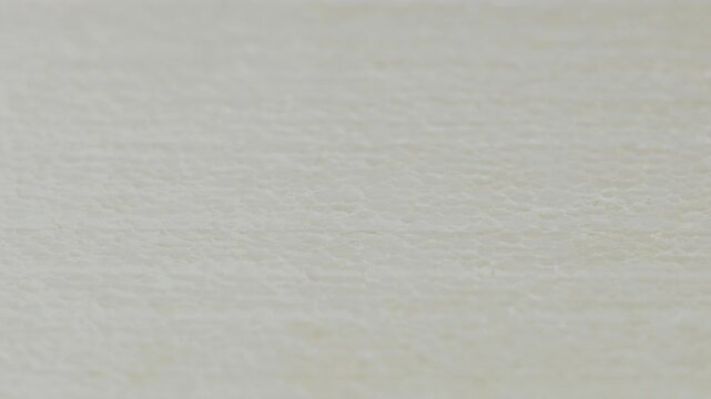 Close-up footage of white expanded polystyrene foam with visible fused beads, porous cellular structure and lightweight insulation texture for construction and material backgrounds.