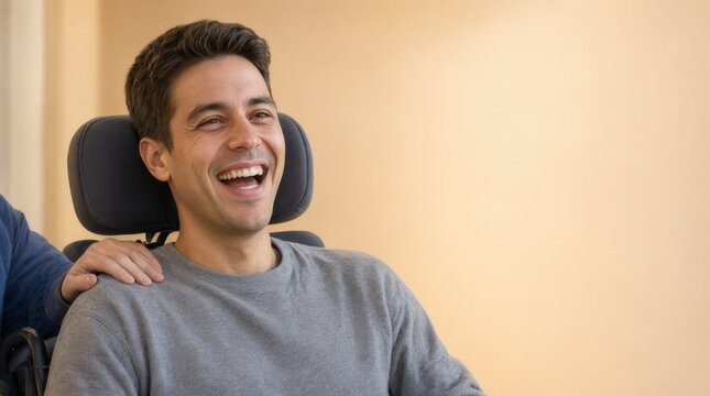 Happy disabled man in wheelchair laughing with friend indoors, positive lifestyle, inclusion, support and joy concept.