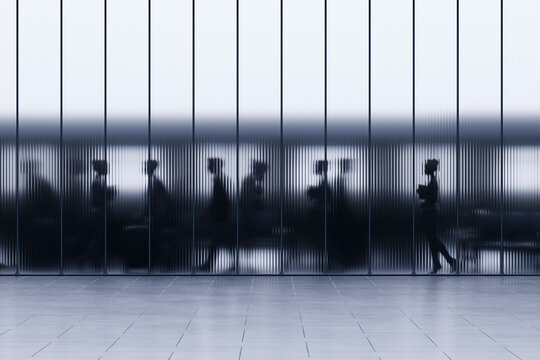 3D crowded train station concourse with commuter silhouettes behind fluted glass wall