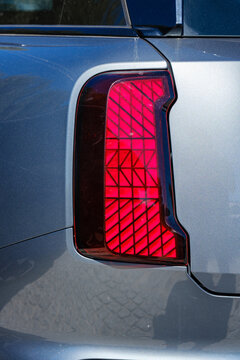 Modern rear tail light with geometric grid led lighting pattern on silver metallic body panel