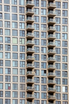 High-rise, skyscraper, many floors, residential building, exterior view, modern, steel and glass, windows, rain, gray.