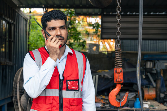 Indian Engineer Control Operate Construction Site with Walkie Talkie with Heavy Machinery Crane Hook