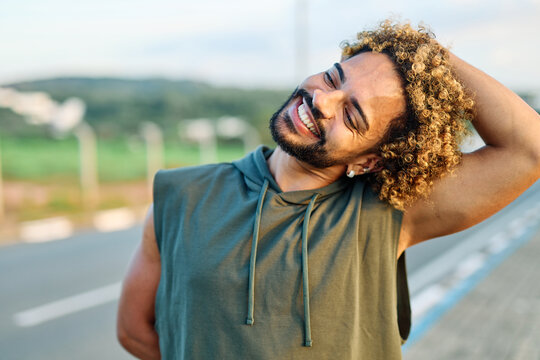 Portrait os a happy bhandsome black  man exercising and stretching outdoors