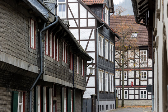 Historic street in Goslar, Germany is lined with traditional half timbered houses and slate facades. Autumn scenery highlights medieval architecture, heritage, charm and old European town atmosphere