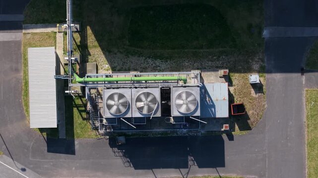 Top-down aerial drone view of rotating axial flow cooling fans on a factory roof in Goole, UK