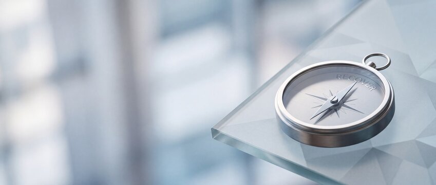 Compass navigation tool on transparent glass surface.