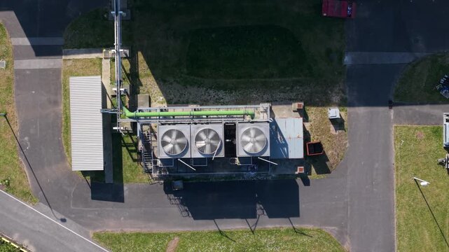 Rotating industrial axial fan cowls and chiller units, aerial drone tracking shot in Goole, UK