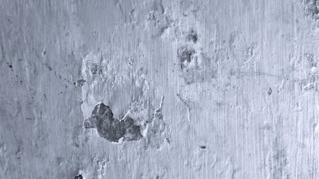 Weathered monochrome plaster wall with layered peeling paint, irregular patches and rough surface details, offering a raw industrial texture background.