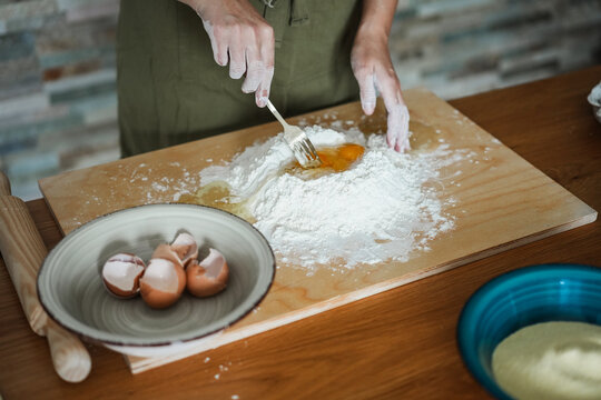 Woman preparing dough for tagliatelle at home - Handmade food and italian culture concept - Main focus on dough - UGC content