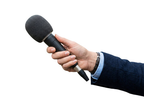 Hand in a blue suit sleeve holding a handheld microphone with a black foam windscreen.