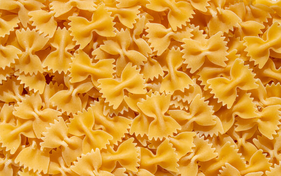 Dry farfalle bow tie pasta texture background for Italian cooking