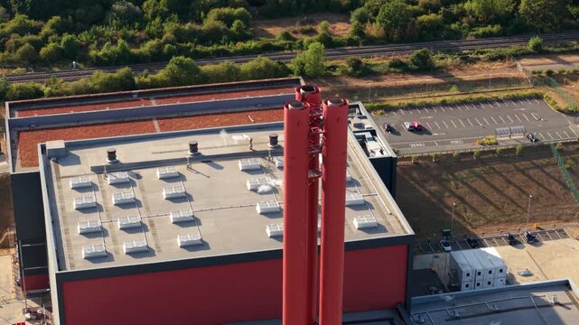 Aerial view of Rookery South ERF and Millbrook Power plant with its prominent red chimney stack and industrial rooftops in Stewartby, England, United Kingdom.