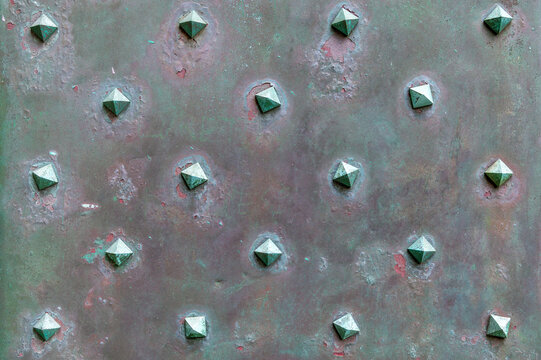 Rusted metal panel with rivets arranged in grid pattern