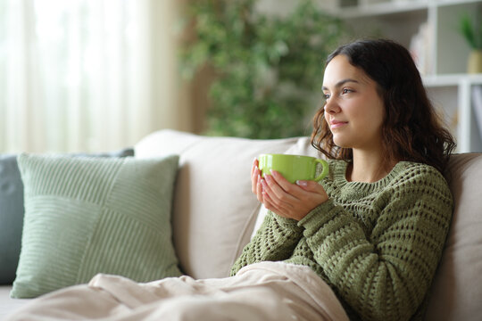 Young woman drinking coffee in winter and thinking in winter