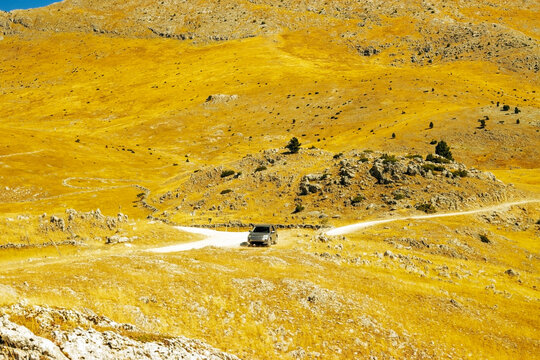 Off-Road Vehicle Traveling Through Remote Karst Mountain Landscape in Bosnia and Herzegovina