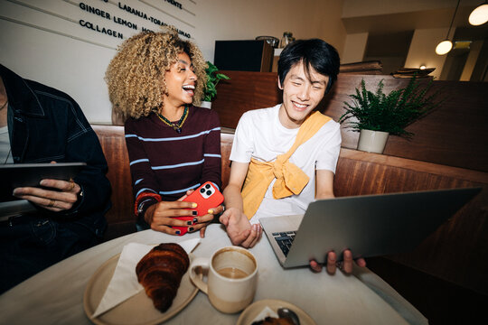 Young business people from Generation Z collaborating in cafe culture