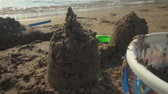 Beach castle pointy sharp sand bucket children kids water sunlight